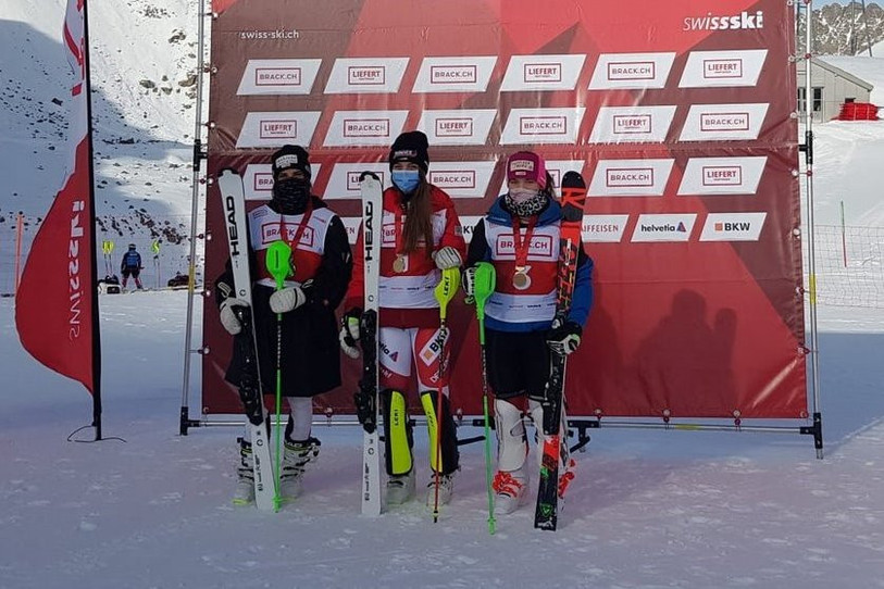 Amélie Klopfenstein (au centre) tient son premier titre national (photo : Swiss-Ski).