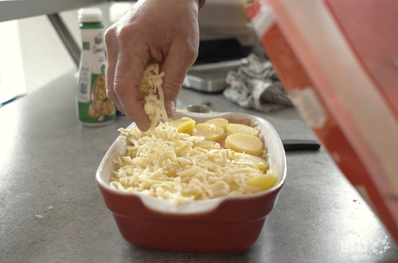 Plusieurs couches de pommes de terre, de saumon et de Gruyère dans le plat à gratin…