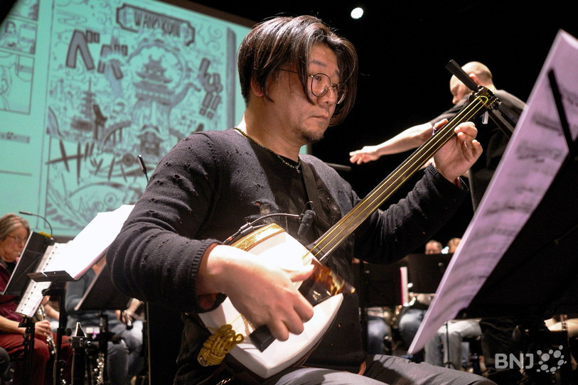 Hideaki Tsuji musicien professionnel accompagne l’Harmonie Shostakovich avec son shamisen, sorte de luth à trois cordes.