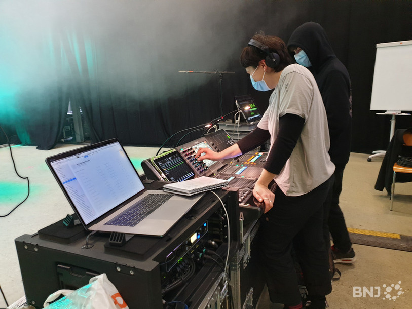 Deux apprentis techniscénistes en première année effectuent les derniers réglages de son avant le début du premier concert.