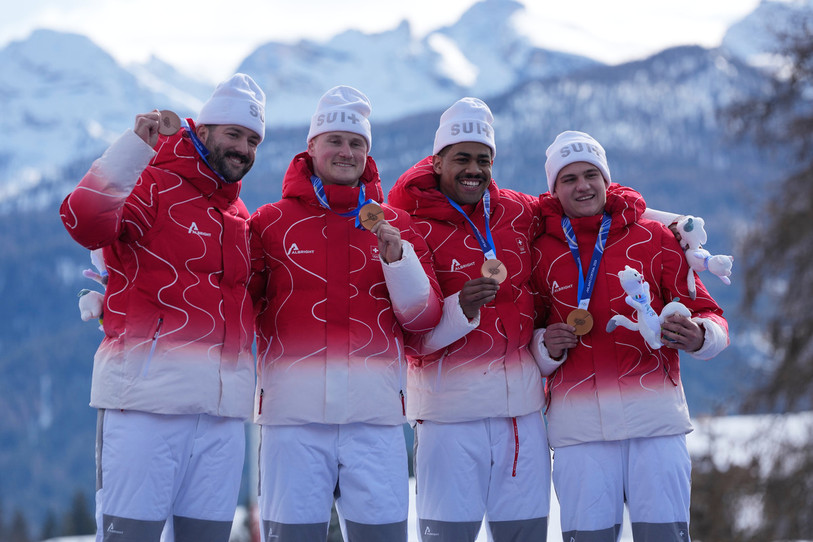 Michael Vogt, Andreas Haas, Amadou David Ndiaye et Mario Aeberhard sur e podium du bob à 4 à Cortinal. (AP Photo/Alessandra Tarantino)