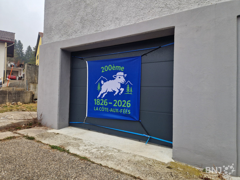 Le drapeau des 200 ans de La Côte-aux-Fées sur un garage de la commune.