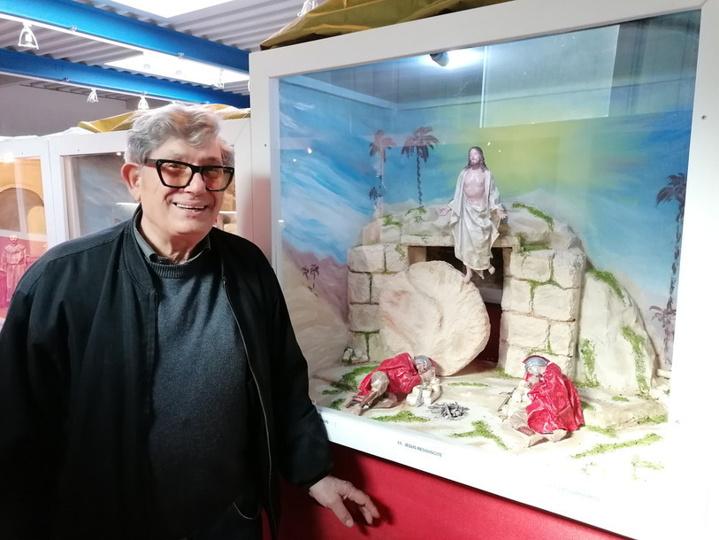 Giovanni Resta à côté d’un diorama qui représente la résurrection de Jésus.