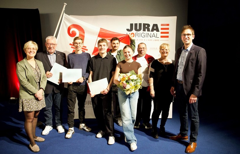 La présidente du Gouvernement jurassien Rosalie Beuret Siess (à g.) et le ministre des Sports Raphaël Ciocchi entourent les lauréats des Mérites sportifs jurassiens 2025. (Photo : BIST / Roland J. Keller)