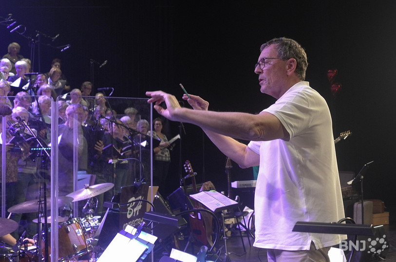 Blaise Héritier face à ses chanteurs et musiciens en répétition sur la scène du Théâtre du Jura.