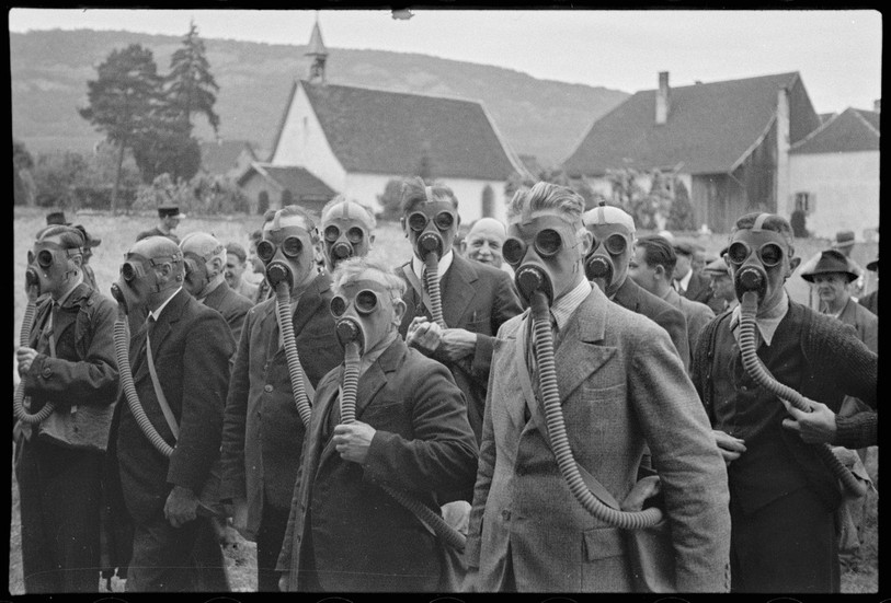 Le maniement du masque à gaz sur la place de l’étang à Delémont avant l'éclatement de la Seconde Guerre mondiale, par Enard frères. (Photo : Musée jurassien d’art et d’histoire, Delémont.)