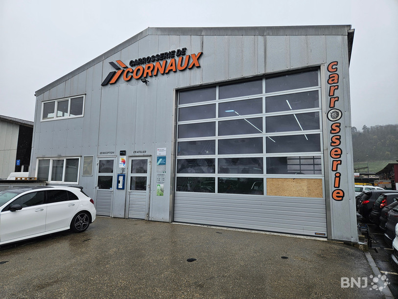 Sur la droite de la porte du garage de la carrosserie de Cornaux, on voit le plexiglas cassé par les malfrats pour entrer dans l'atelier et y dérober les clés de voitures.