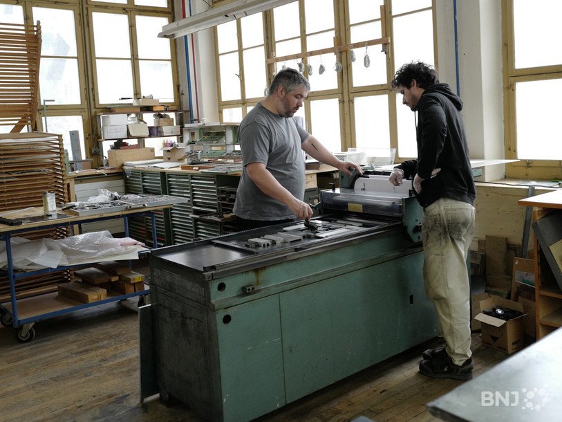 Simon Beuret et Augustin Rebetez travaillent sur une presse typographique dans l’atelier de gravure à Moutier