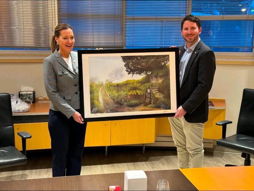 Jonathan Gretillat a offert un tableau de John Howe (le dessinateur canadien résidant à Neuchâtel) à la mairesse de Blainville, Liza Poulin. (Photo: Ville de Neuchâtel)