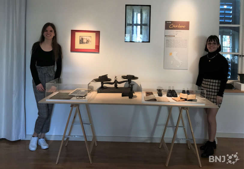 La table présentant les objets appartenant à la famille de Axalia Vollmer (ici à droite) en compagnie de Laetitia Brugnerotto.