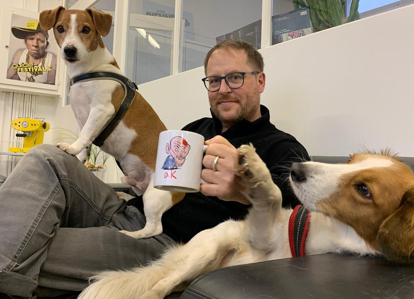 Jean-Luc Itten présente une tasse à l'effigie de Daniel Koch en compagnie de ses chiens. (Photo: Yann Staffelbach)