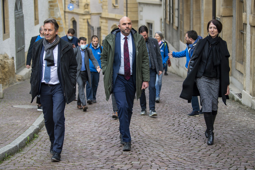 De gauche à droite : Alain Ribaux, Laurent Favre et Crystel Graf, au moment de monter au Château de Neuchâtel lors du premier tour des élections cantonales neuchâteloises le dimanche 18 avril 2021.  (Photo : KEYSTONE / Jean-Christophe Bott).