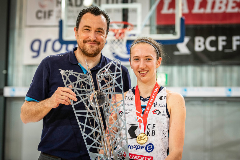 L'Ajoulote Justine Sollberger n'est pas entrée en jeu mercredi soir mais a tout de même soulevé le trophée en compagnie de son entraîneur, ancien technicien du BC Boncourt, Romain Gaspoz (photo : Stéphane Bée).