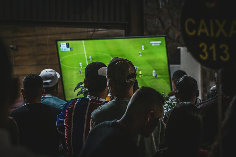 Image prétexte de supporters de foot devant la télé. Source : Unsplash