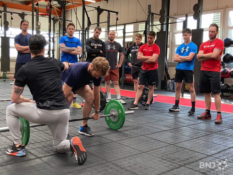 Le préparateur physique Jordan Eschmann (de dos) démontre un exercice en compagnie de Reto Schmutz.