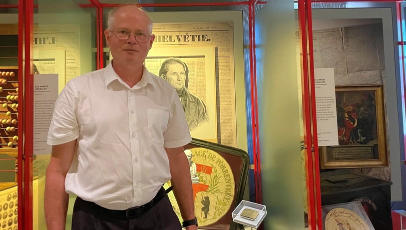 Marc Lambelet, concepteur de l'exposition, devant la plaque commémorative du Serment de Morimont