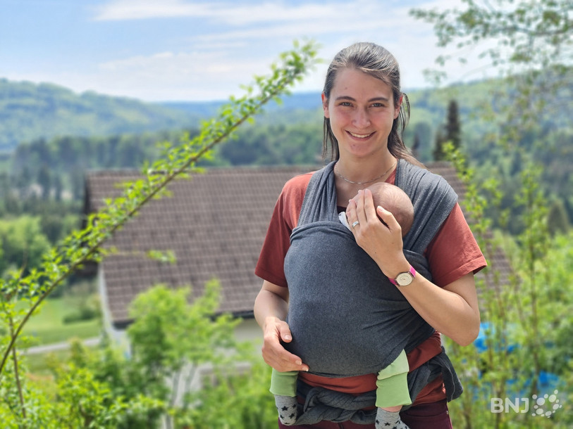 Julie Gafner et son petit dernier de cinq semaines dans le jardin de la maison familiale au Fuet.
