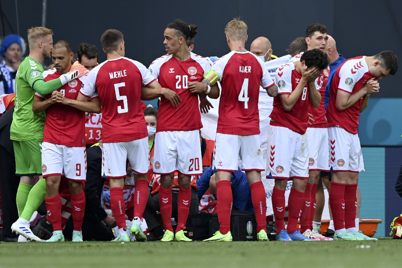 Les joueurs danois entourent Christian Eriksen, soigné par une équipe médicale. (Photo : Stuart Franklin/Pool via AP).
