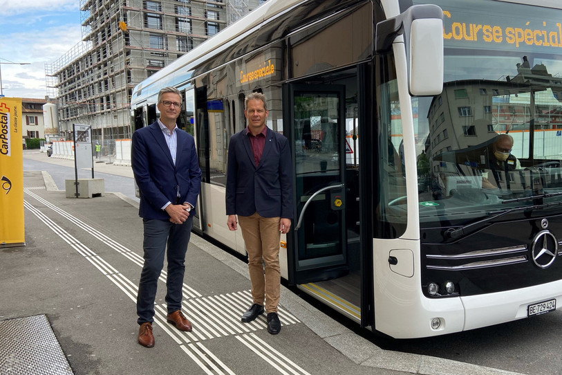 Philippe Cina, responsable du marché Suisse romande chez Car Postal, et David Eray, ministre jurassien de l'environnement, posent devant le bus électrique. (Photo : Car Postal).