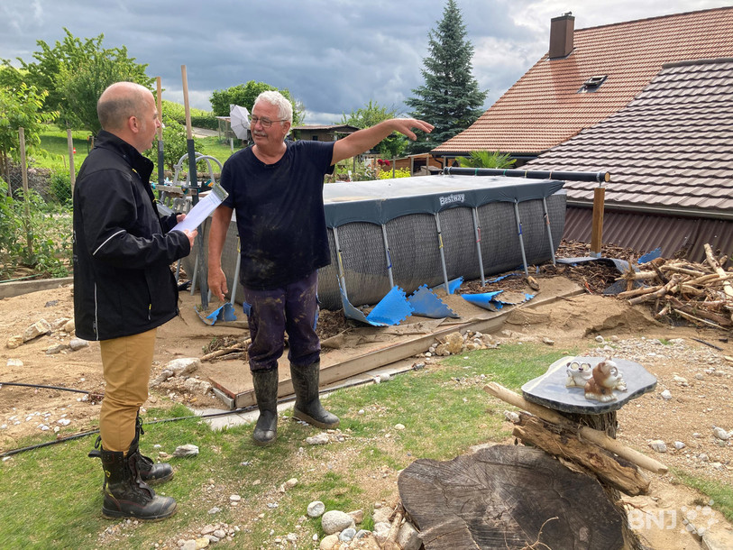 Le responsables des sinistres à l'ECAP Massimo Vitalba estime les dégâts dans le jardin d'un habitant de Cressier, Raymond Fuchs.