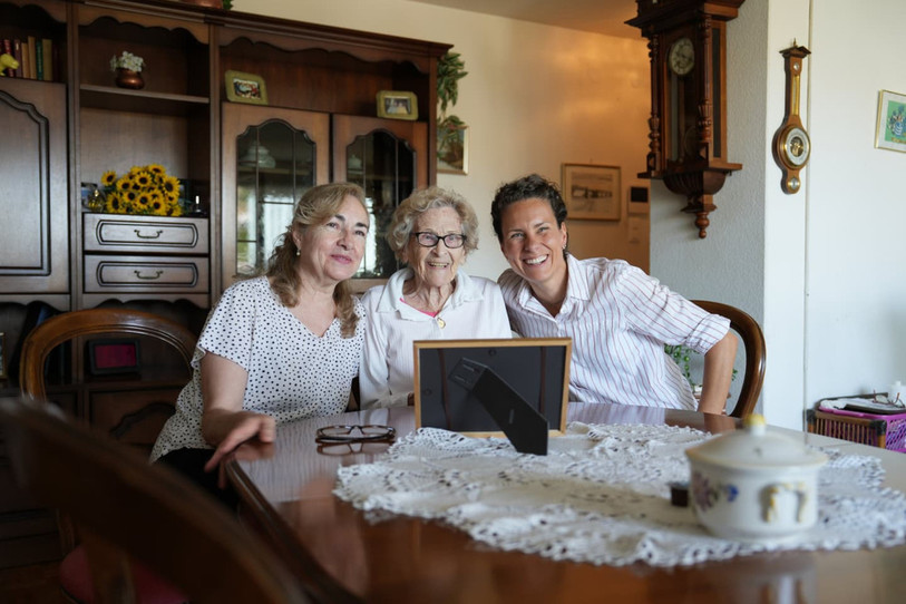 Aux côtés d’Amada Fernandez, bénévole à la CRS, Phanee de Pool rend visite à Ginette Costa, 96 ans. (Photo : Croix Rouge Suisse)