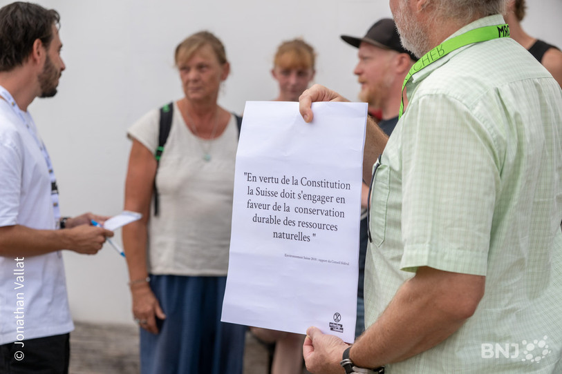 De grandes feuilles en papier ont été jetées au sol par les militants venus protester à Saignelégier. (Photo : Jonathan Vallat)