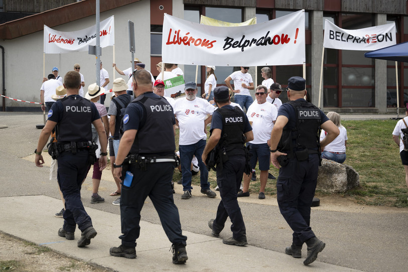 Tout un symbole… Des policiers patrouillent devant des militants autonomistes avec des banderoles « Libérons Belprahon ! », lors du 121e Marché-Concours (KEYSTONE/Anthony Anex.)