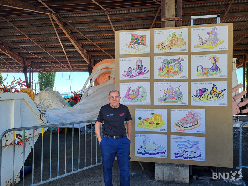 Freddy Flühmann pose devant les dessins de chars réalisés par son fils et exposés au chantier de Neuchâtel.