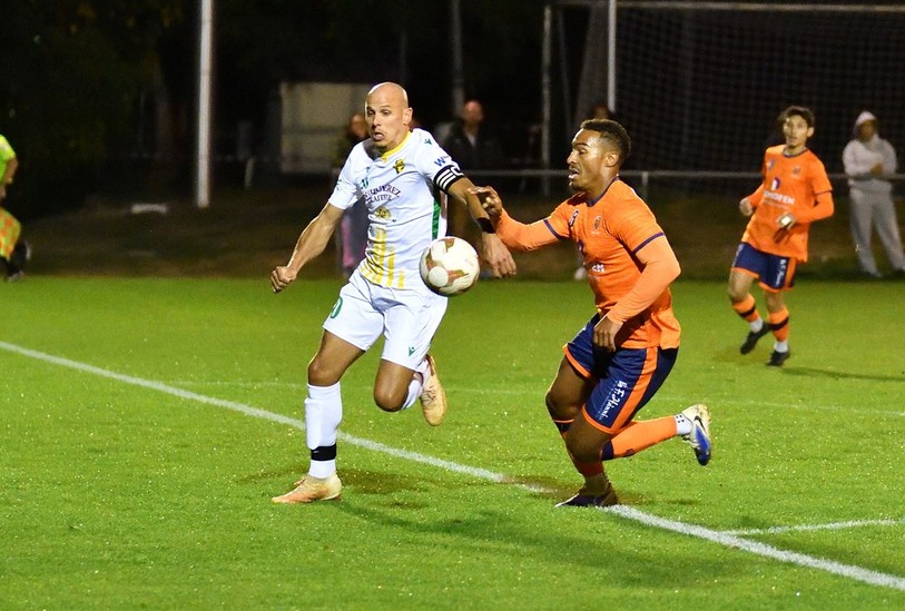Hervé Tschanz (en orange et mauve) et le FC Ajoie-Monterri ont pris le dessus sur le FC Haute-Ajoie du capitaine Franck Quiquerez mercredi soir à Grandfontaine. (Photo : Georges Henz).