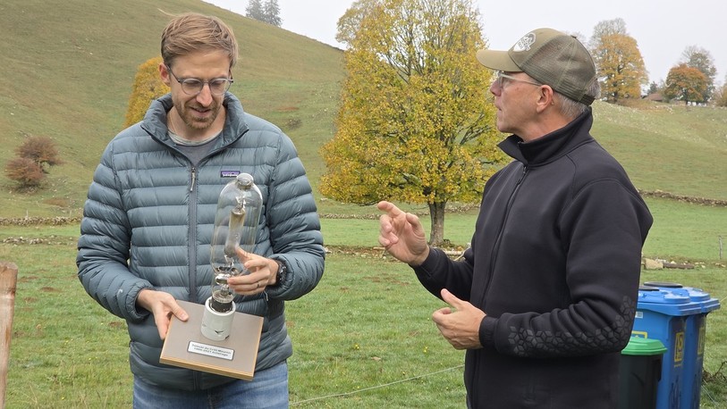 Léonard Reichen et Stéphane Miserez, membres de l’Association du téléski du Crêt-Meuron, présentent une ancienne ampoule énergivore, remplacée par des LED dans le cadre de leur transition énergétique. 