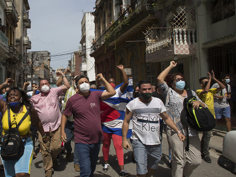 Des manifestants dénonçant l'action du gouvernement marchent dans les rues de La Havane. CREDIT: KEYSTONE/AP/Ismael Francisco