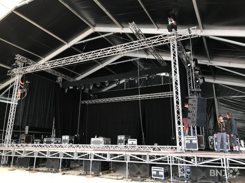 Les techniciens s'affairent au montage de la scène principale.