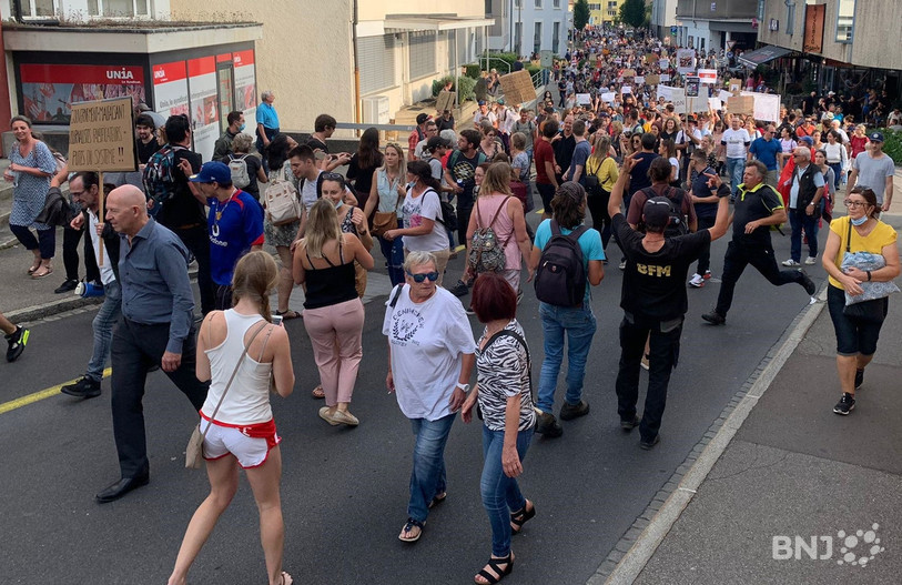 Une affiche, ici à gauche de l'image, qualifie les journalistes de « falsificateurs »
et de « Putes du système » lors de la manifestation contre l'extension du certificat Covid lundi à Delémont.