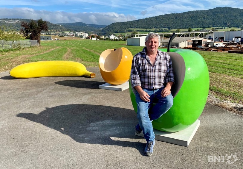 Christian Schneiter pose dans un de ses fruits géants croqués qui ont été réalisés dans la cimenterie des Matériaux Sabag à Delémont.