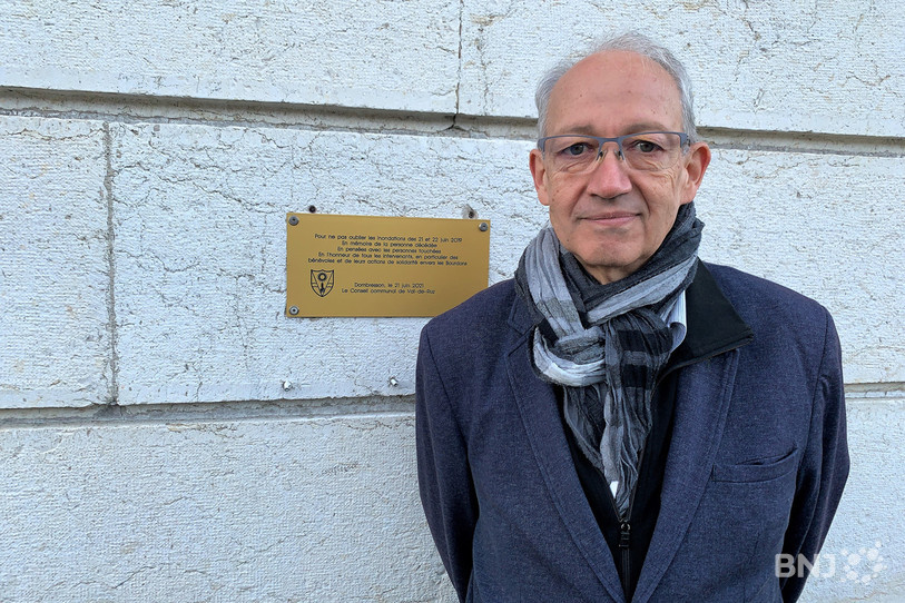 Le conseiller communal François Cuche, chef du dicastère de la sécurité, devant la plaque commémorative posée au collège de Dombresson.