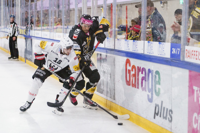 L'image symbolise la rencontre : le HC Ajoie (ici Maxime Fortier) a mis de la volonté dans l'effort, mais le leader Fribourg (ici Ryan Gunderson) n'était pas facile à bousculer. (photo : KEYSTONE/Manuel Lopez)
