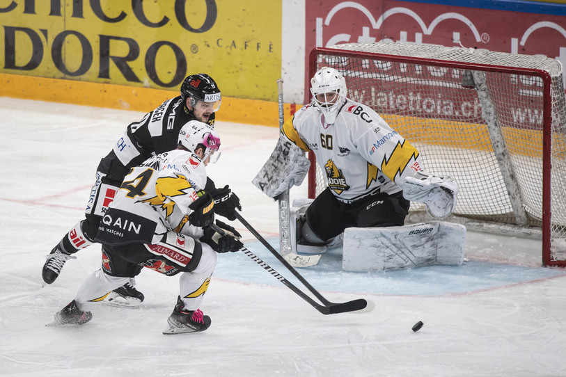 Le gardien du HC Ajoie Viktor Östlund reçoit l'appui du défenseur Daniel Eigenmann pour stopper le Luganais Libor Hudacek (photo : KEYSTONE/Ti-Press/Pablo Gianinazzi).