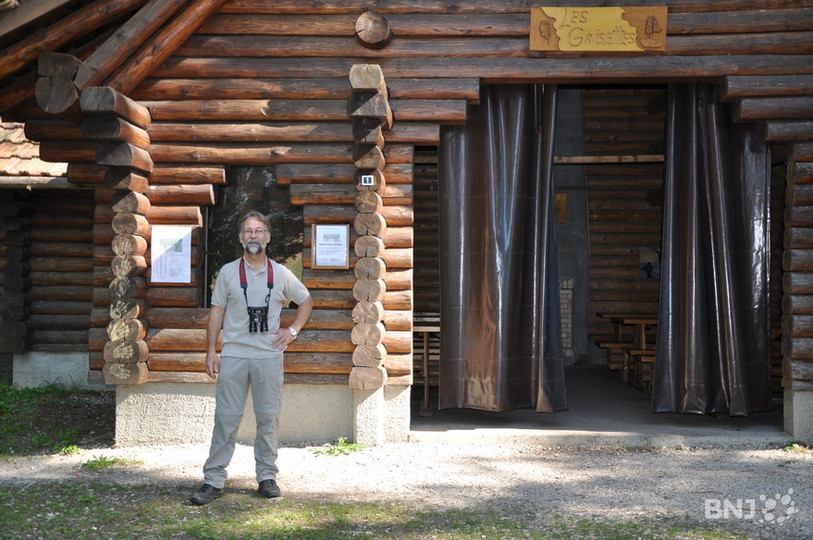 Marcel Chalet devant la signalétique du sentier des arbres