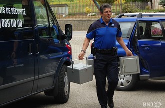Les assistants de sécurité amènent les enveloppes de vote à La Rebatte à Chézard-St-Martin. 