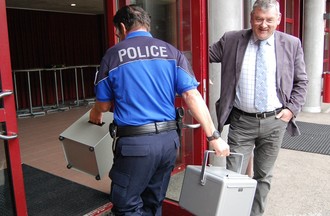 Les assistants de sécurité amènent les enveloppes de vote à La Rebatte à Chézard-St-Martin. 