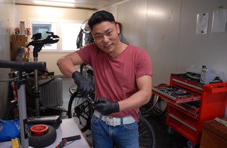  Bir, résidant du Bouthan dans l'atelier en train de réparer son vélo.