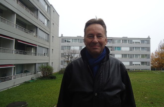 Alain Ribaux devant l'immeuble de son enfance à la rue du Chasselat
