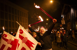 Des personnes defilent pendant le cortege aux flambeaux lors des festivites marquant le changement de canton de la ville de Moutier le mercredi 31 decembre 2025 a Moutier. La Ville de Moutier devient jurassienne le 31 decembre 2025 a minuit lors d'une "Nuit pour l'histoire". La Ville de Moutier avec ses 7300 habitants va vivre mercredi une journee historique: a l'issue des douze coups de minuit, la cite prevotoise sera jurassienne. Partie officielle, banquet, cortege aux flambeaux et spectacle son et lumiere accompagneront les dernieres heures de Moutier dans le canton de Berne. (KEYSTONE/Jean-Christophe Bott)
